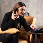 a girl sitting on a couch and talking on a telephone