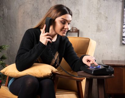 a girl sitting on a couch and talking on a telephone